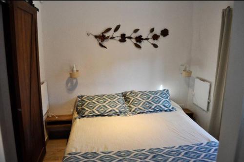 ein Schlafzimmer mit einem Bett und einem Ast an der Wand in der Unterkunft Cabana 7 loma de la cruz in Tafí del Valle