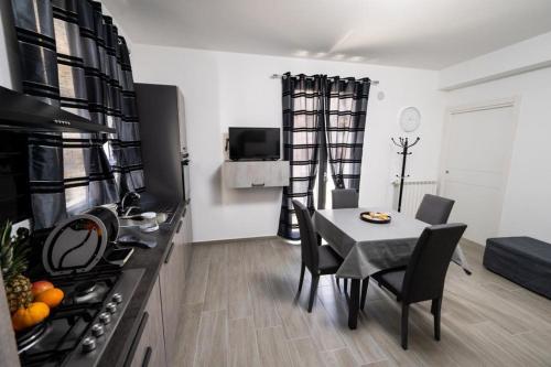 a kitchen and dining room with a table and a stove at AVA VACATION HOME in Borgetto