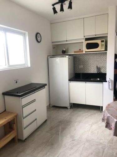 a kitchen with a refrigerator and a microwave at Rua Dr. Diogo de Faria, 671 apto 22 in Sao Paulo