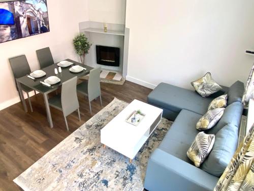 een woonkamer met een bank en een tafel bij Town Center Retreat 2 Bed Gem with Free Parking and Garden in Buckinghamshire