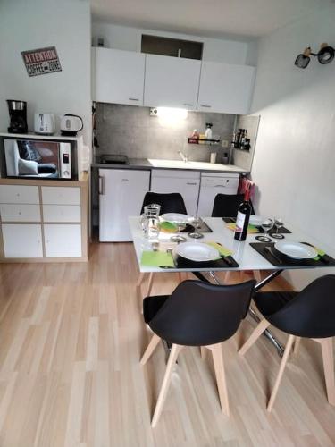 - une cuisine avec une table à manger, des chaises et un comptoir dans l'établissement Appartement dans une Résidence Calme (4 Personnes), à Saint-Lary-Soulan