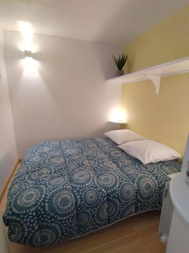 sypialnia z łóżkiem z niebiesko-białym kocem w obiekcie Appartement dans une Résidence Calme (4 Personnes) w mieście Saint-Lary-Soulan
