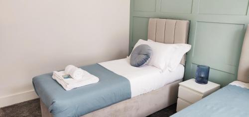 Un pequeño dormitorio con una cama con toallas. en Gilpin House, en Leeds