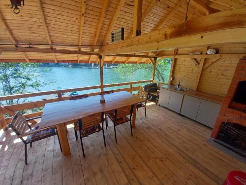una gran mesa de madera en una cabaña con una gran ventana en Cabana Gavroche en Moara Ungurului