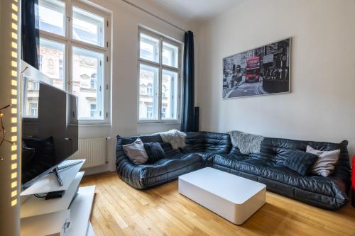 プラハにあるLesser Town Apartment Melnicka by easyBNBのリビングルーム(黒い革張りのソファ、テーブル付)