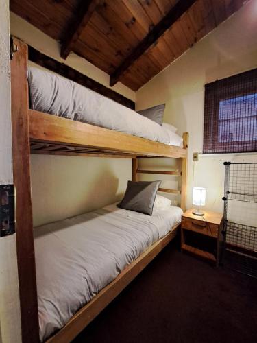 a bedroom with two bunk beds and a night stand at Hostal Boutique CUMBRES in Farellones