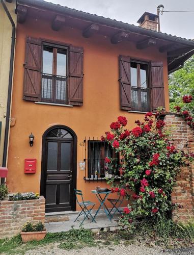 een huis met bloemen en een zwarte deur en ramen bij Il giardino di Alcesti in Pino Torinese