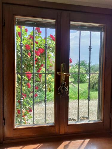 een raam met uitzicht op een bos met rode bloemen bij Il giardino di Alcesti in Pino Torinese
