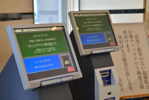 two computer monitors sitting next to a ticket machine at Canal City Fukuoka Washington Hotel in Fukuoka