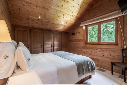 1 dormitorio con 1 cama en una cabaña de madera en Prado do Xisto - Chalé de madeira a 7km de Braga, en Braga
