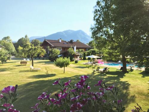 a park with a house and a swimming pool at Hotel Maier zum Kirschner in Rottach-Egern