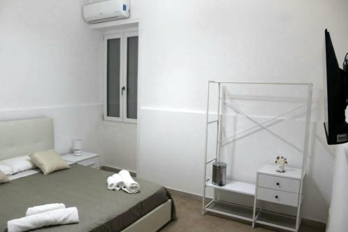 ein weißes Zimmer mit einem Bett und einem Spiegel in der Unterkunft WHITEHOUSE in Lecce