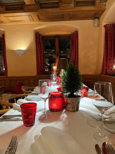 a table with wine glasses and a christmas tree on it at Hotel Maier zum Kirschner in Rottach-Egern