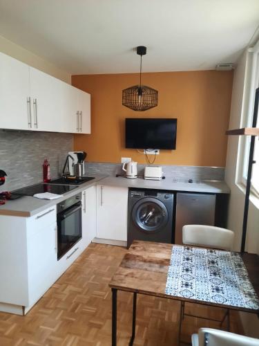 une cuisine avec une machine à laver et une table dans l'établissement Studio Jean Jaures, à Chalon-sur-Saône