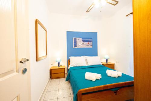 a bedroom with a blue bed with towels on it at Isidora Summer House in Skala Fourkas