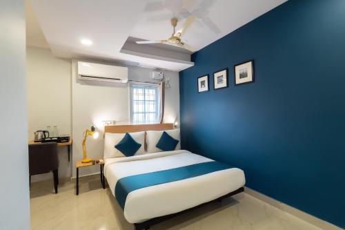 een blauwe slaapkamer met een bed en een blauwe muur bij Silverkey Himayat Nagar Circle Near Snow World in Hyderabad