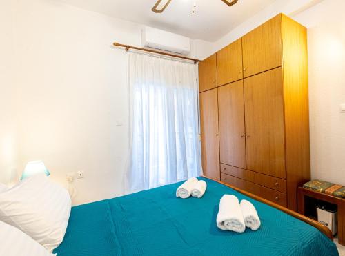 a bedroom with two towels on a blue bed at Isidora Summer House in Skála Foúrkas