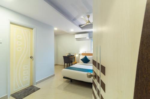 a hotel room with a bed and a door at Silverkey Himayat Nagar Circle Near Snow World in Hyderabad
