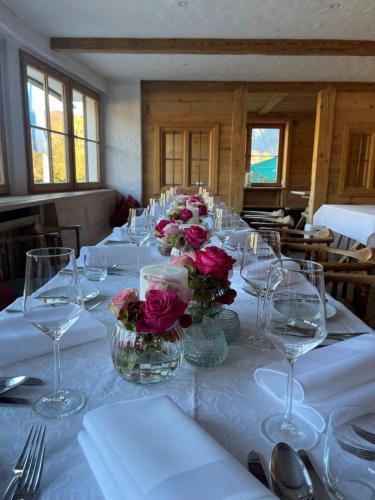 a table with wine glasses and flowers on it at Hotel Maier zum Kirschner in Rottach-Egern