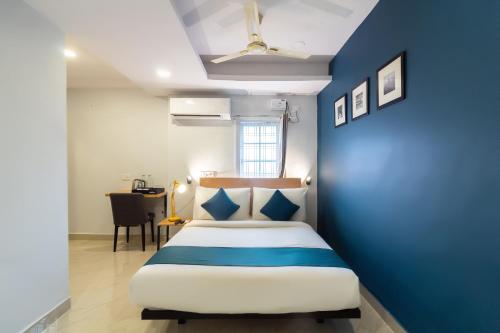 een bed in een kamer met een blauwe muur bij Silverkey Himayat Nagar Circle Near Snow World in Hyderabad