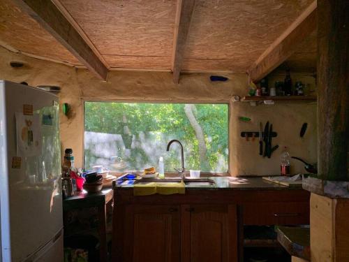 una cocina con fregadero y una ventana en una casa en Cabaña La Sencillita, en Neptunia