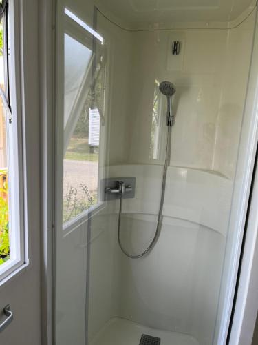 eine Dusche im Bad mit Glastür in der Unterkunft Mobil home climatisé in Lège-Cap-Ferret
