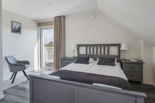 a bedroom with a bed and a chair and a window at Domek nad Zalewem in Kluszkowce