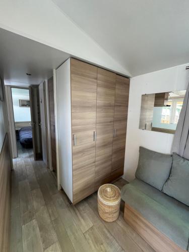 uma sala de estar com um sofá e armários de madeira em Mobil home climatisé em Lège-Cap-Ferret