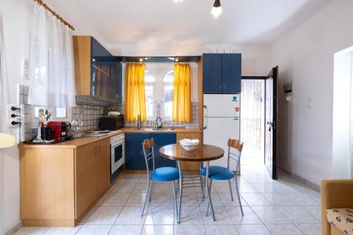 a kitchen with blue cabinets and a table and chairs at Isidora Summer House in Skála Foúrkas