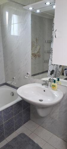 een badkamer met een wastafel, een bad en een spiegel bij Hill View 4 in Alexandroupoli