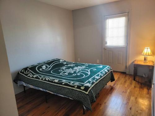 a bedroom with a bed and a table and a window at Private Apt Near Ferry and Park in Tompkinsville