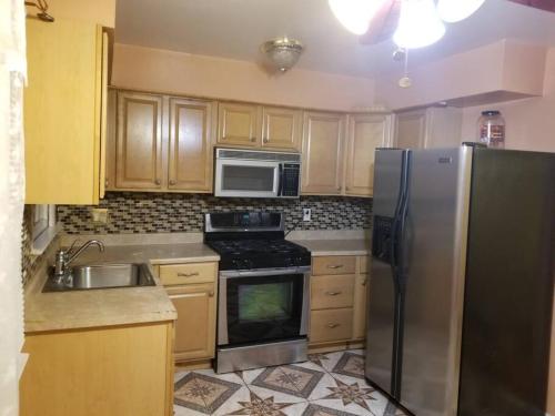 uma cozinha com um frigorífico de aço inoxidável e um lavatório em Private Apt Near Ferry and Park em Tompkinsville