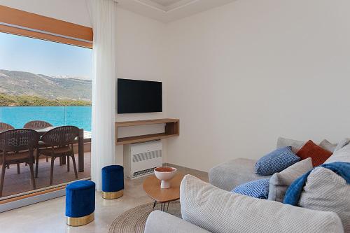 uma sala de estar com um sofá e uma televisão em Villa Amari waterfront, step to the sea and berth em Bogišići