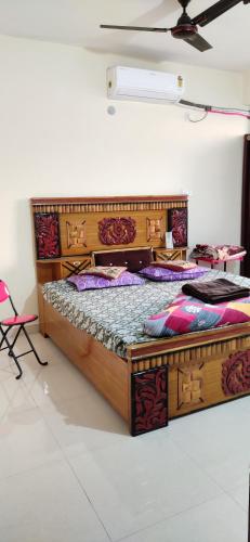 a large wooden bed in a room at unTrained & unPlanned in Jabalpur