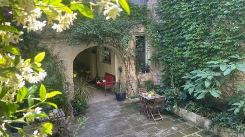 an outdoor patio with a table and chairs and plants at L'ISLE in Beaucaire