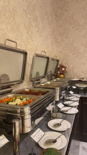 a buffet line with plates of food in a restaurant at Al Wateen Hotel in AlUla