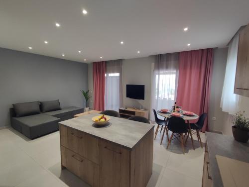 a living room with a couch and a table with chairs at Nostalgia Apartment in Archangelos