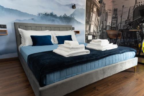 a bedroom with a blue bed with towels on it at B&Business - Fibra ultraveloce, angolo fitness e smartworking, parcheggio coperto in Cosenza