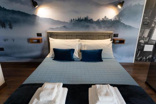 a bedroom with a bed with blue and white pillows at B&Business - Fibra ultraveloce, angolo fitness e smartworking, parcheggio coperto in Cosenza