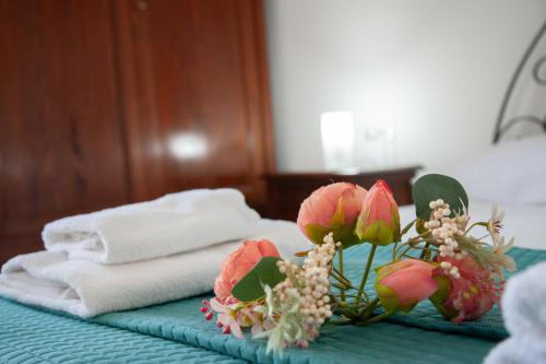 a pile of towels and flowers on a bed at Orlando Bayview in Balestrate
