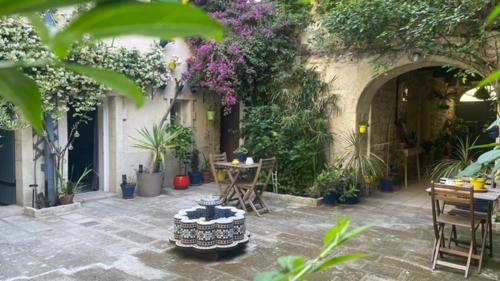 an outdoor patio with a table and chairs and plants at L'ISLE in Beaucaire