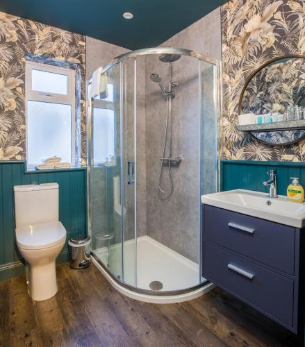 a bathroom with a shower and a toilet and a sink at The Lodges at Castle Lodge in Killarney