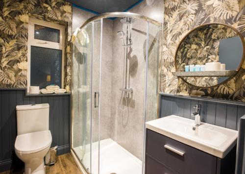 een badkamer met een douche, een toilet en een wastafel bij The Lodges at Castle Lodge in Killarney