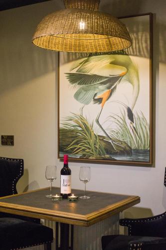 a table with two wine glasses and a painting at The Lodges at Castle Lodge in Killarney