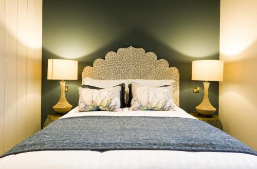 a bedroom with a large bed with two lamps at The Lodges at Castle Lodge in Killarney