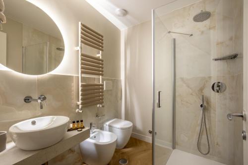 y baño blanco con lavabo y ducha. en Porta Castello Suites, en Roma