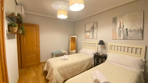 um pequeno quarto com duas camas e uma porta em Aires de Toledo-Parque Warner y Madrid en familia em Toledo