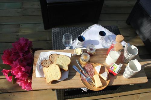 uma mesa de madeira com uma bandeja de pão e torradas em La Cressonnière 56 em Missiriac