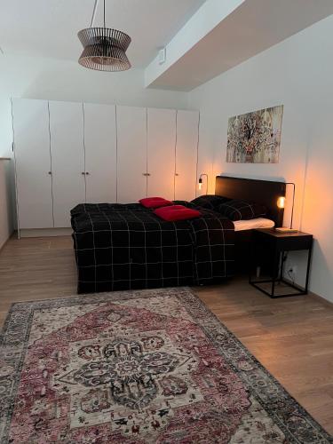a bedroom with a bed and a couch and a rug at Three Monkeys Loft in Hyvinkää
