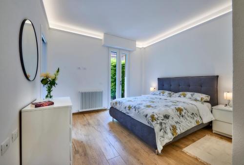 - une chambre blanche avec un lit et un miroir dans l'établissement La casa di Lucia, à Lierna